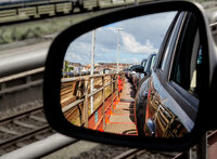 View through the rearview mirror of cars on the upper deck of a car train